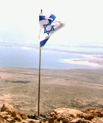 israeli flag with the dead sea view on the background in the judia desert